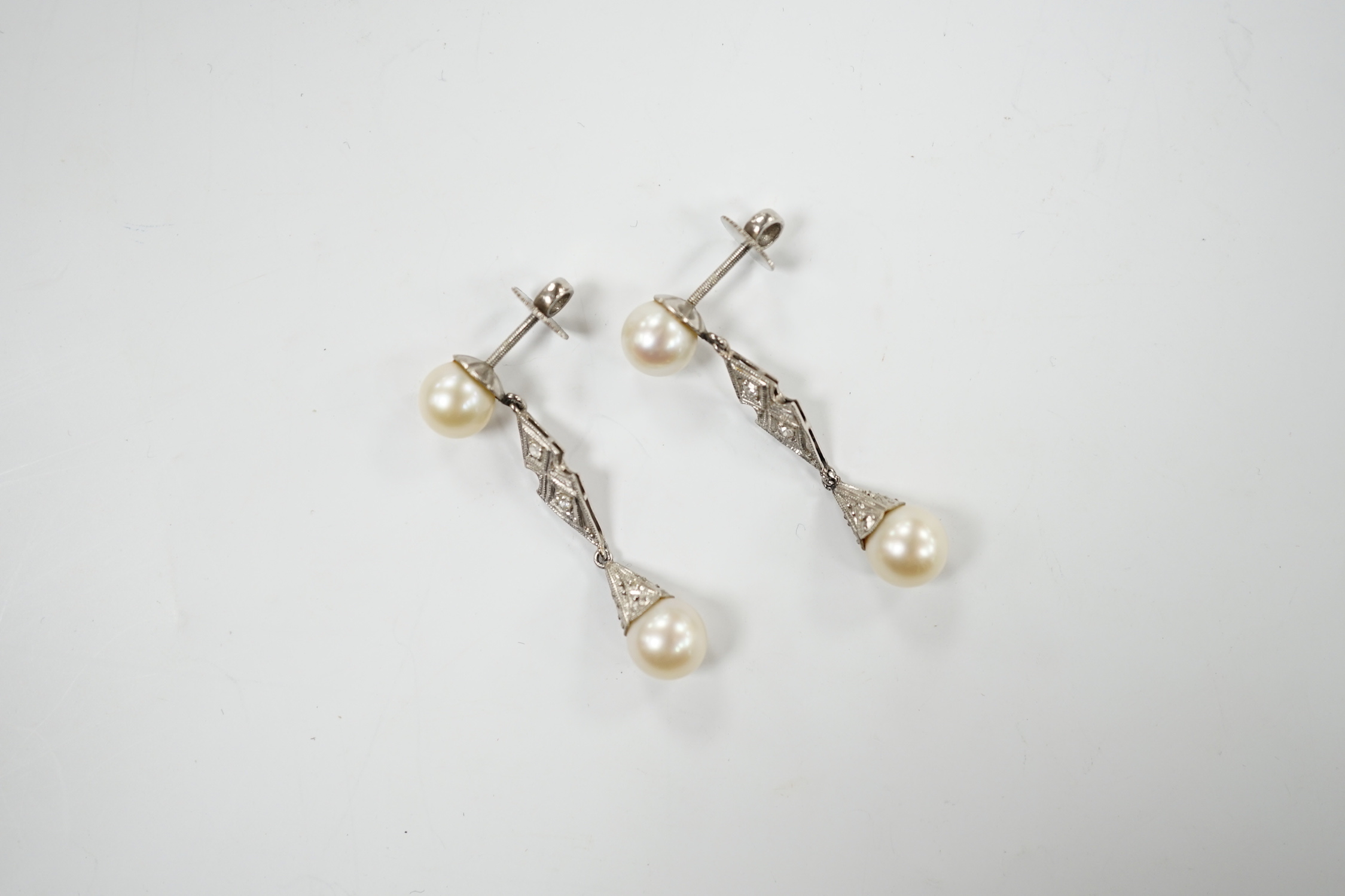 A pair of white metal, two stone cultured pearl and two stone diamond chip set drop earrings, 37mm, gross weight 6.1 grams.